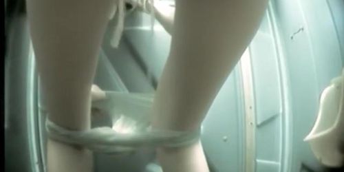 Long legged girl with panty pulled down pissing on toilet